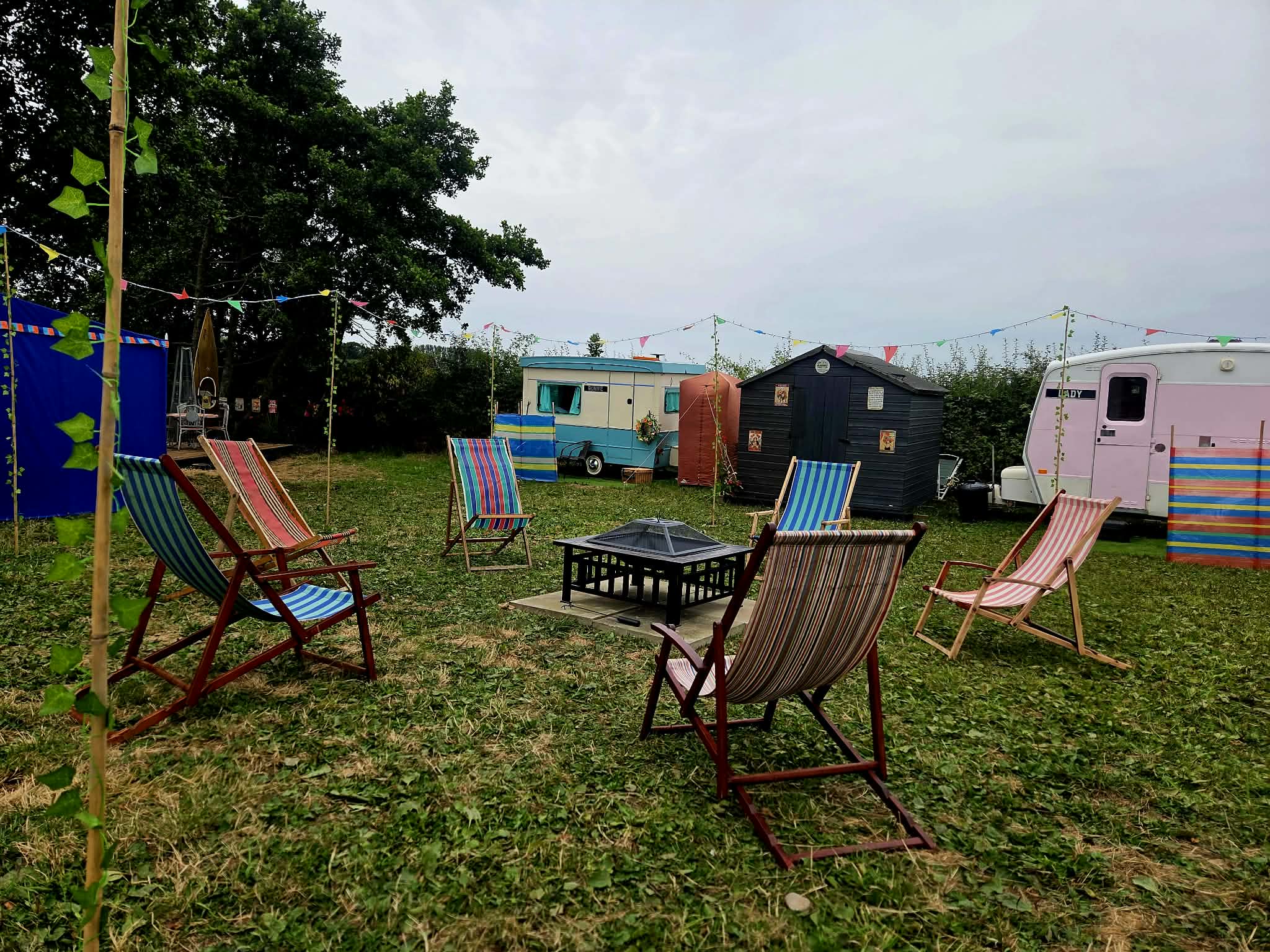 Deck chairs around the communal outdoor seating area with vintage caravans beyond