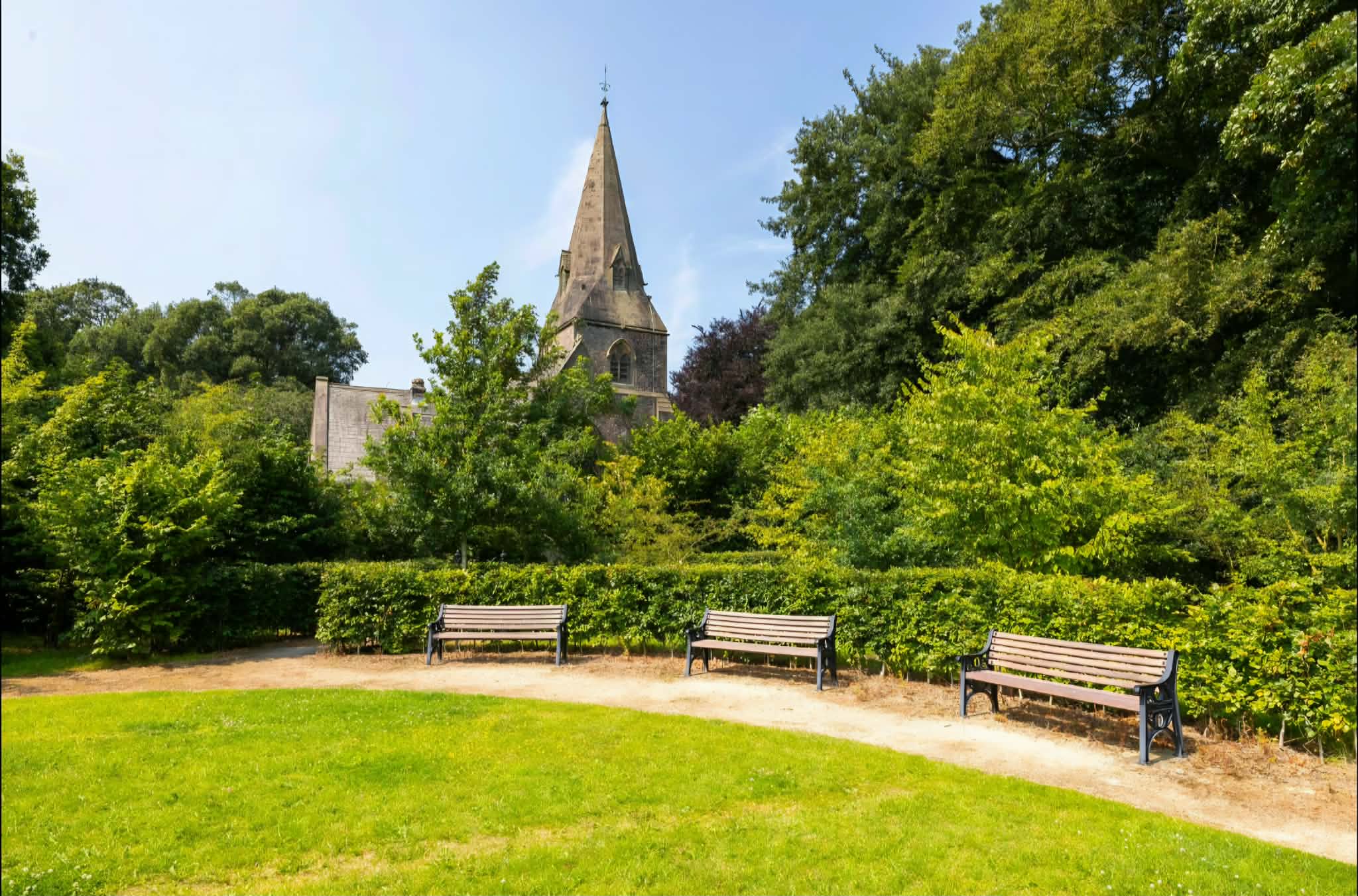Singleton church rising above green village gardens