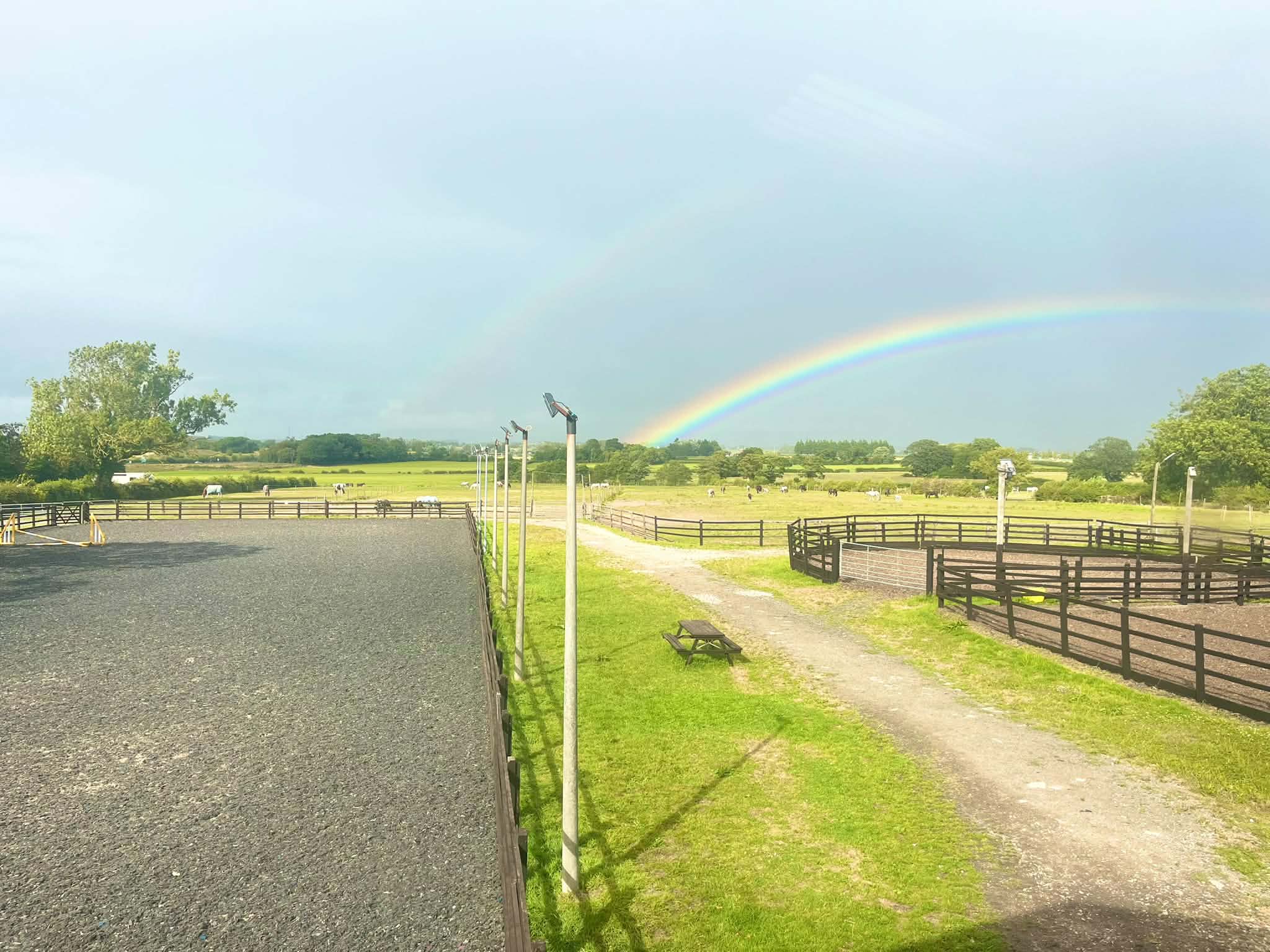 Rainbow stretching across the open grounds and horse paddocks