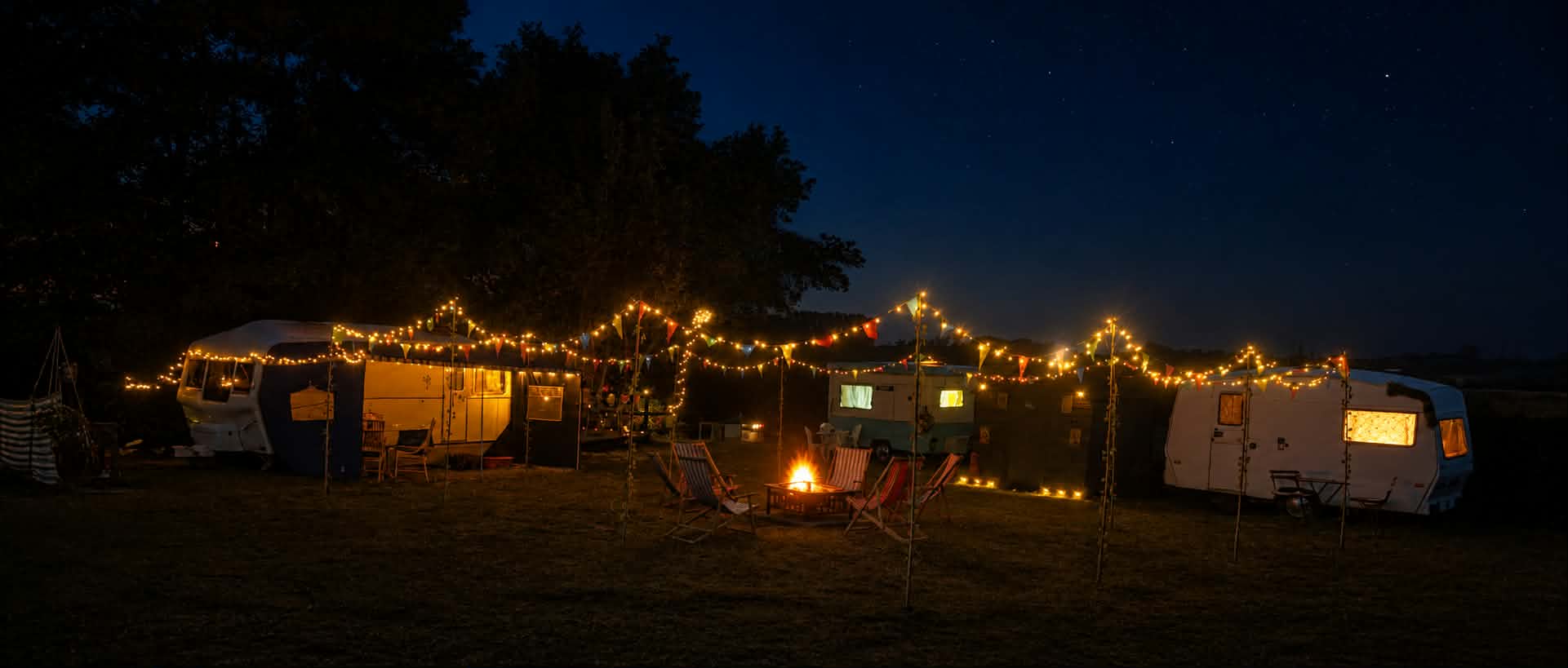 Vintage caravans, festoon lights and a communal firepit beneath the night sky